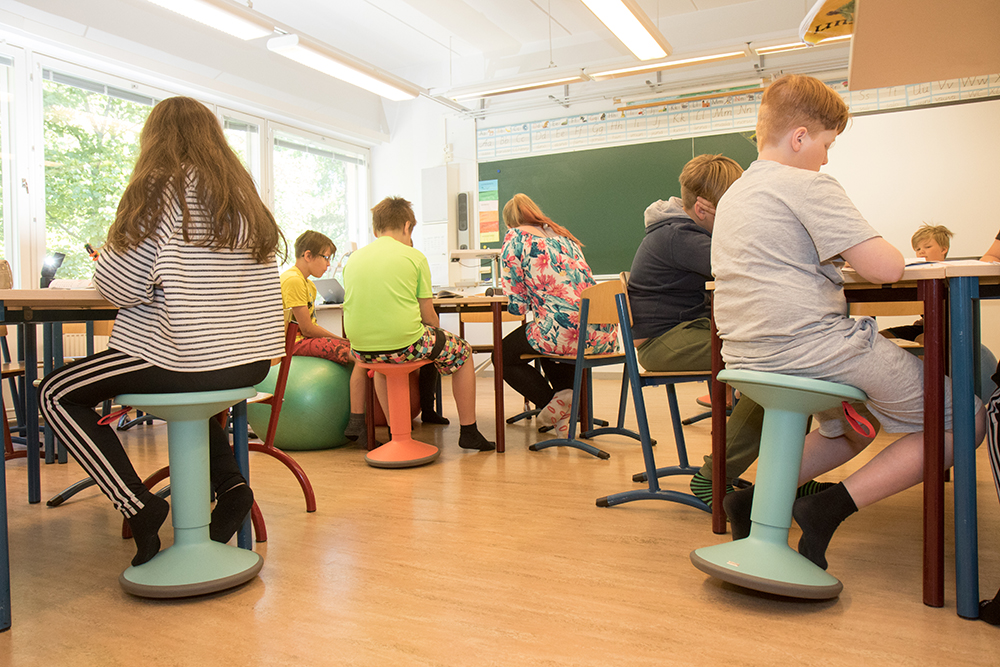 Oppilaat ergonomisilla tuoleilla.